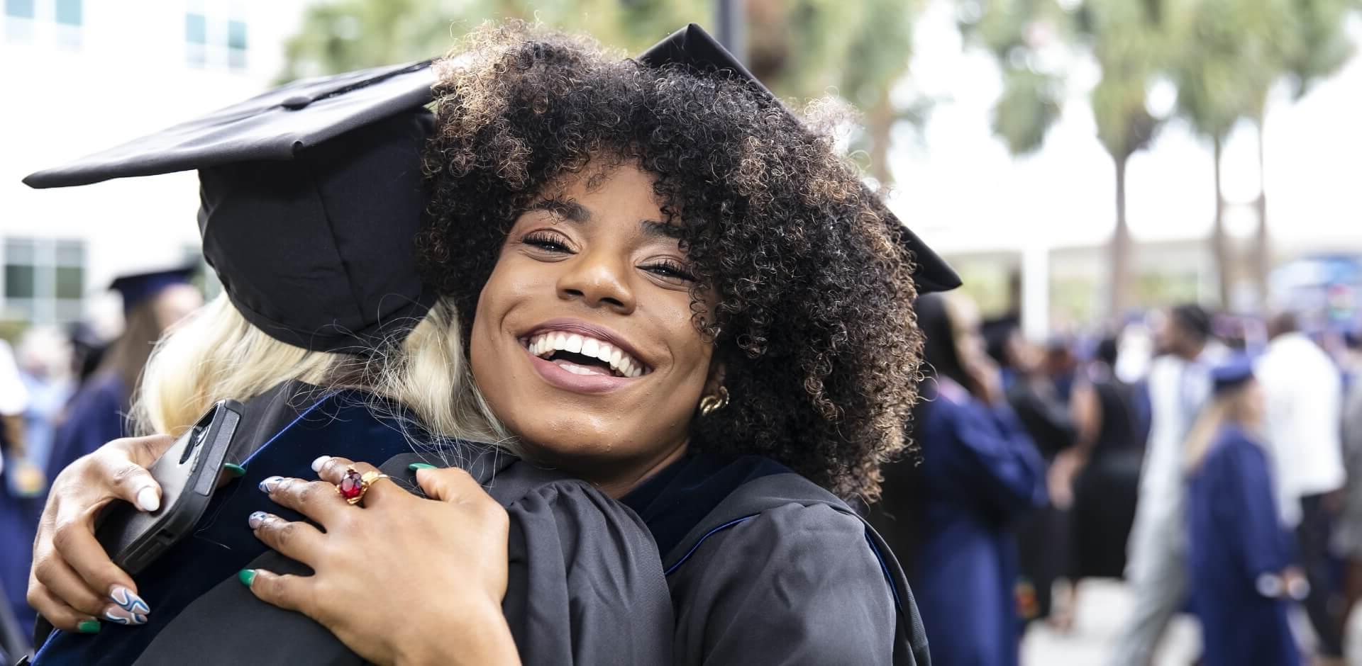 Graduating student hugging and smiling